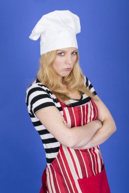 mujer joven enojada y delantal y gorro de chef