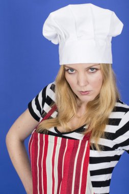 mujer joven enojada y delantal y gorro de chef