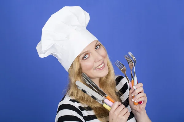 Jonge vrouw in chef-koks hoed, bedrijf keukengerei — Stockfoto