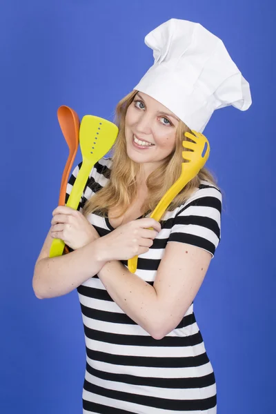 Jeune femme en chef Chapeau tenant des ustensiles de cuisine — Photo