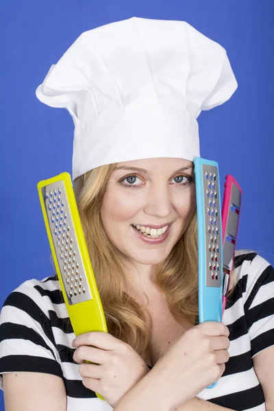 Jeune femme en chef Chapeau tenant des ustensiles de cuisine — Photo