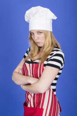 mujer joven enojada y delantal y gorro de chef