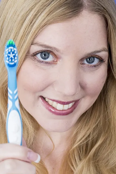Mujer joven feliz sosteniendo un cepillo de dientes — Foto de Stock