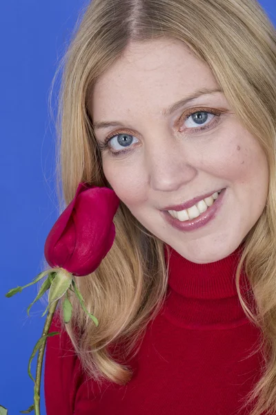 Atractiva joven mujer sosteniendo una sola rosa roja — Foto de Stock
