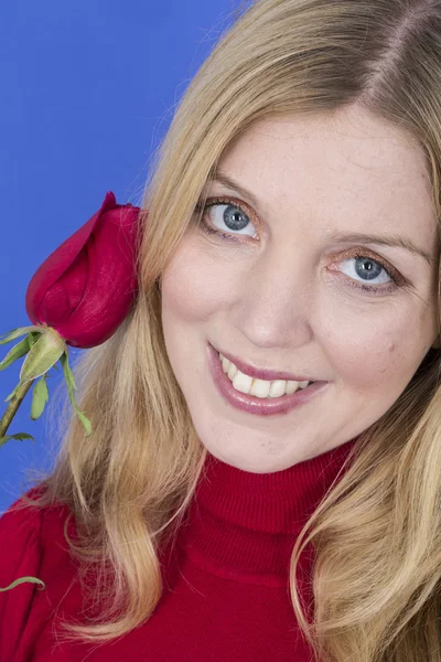 Atractiva joven mujer sosteniendo una sola rosa roja — Foto de Stock