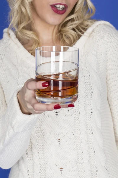 Junge Frau hält ein Glas Whiskey in der Hand — Stockfoto