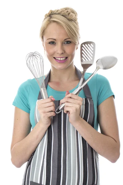 Mulher jovem segurando utensílios de cozinha de aço inoxidável — Fotografia de Stock