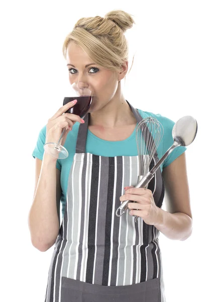 Frau mit Küchenutensilien trinkt Rotwein — Stockfoto