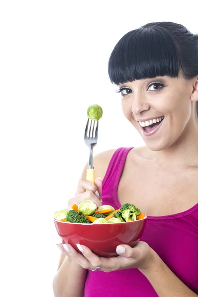 Ung kvinna äter grönsaker — Stockfoto
