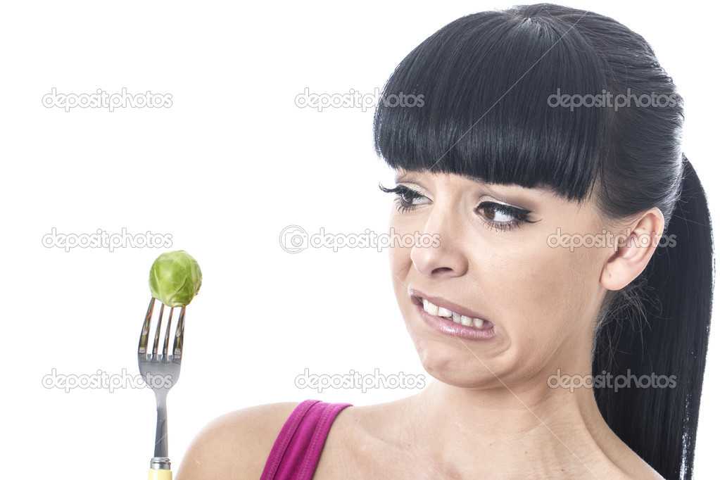 Young Woman Holding Brussel Sprout on a Fork