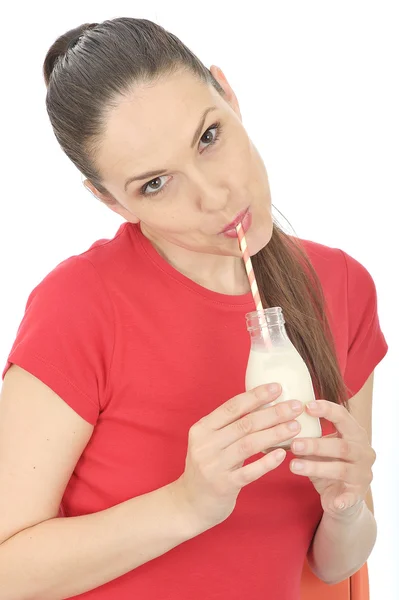 Молода жінка п'є молоко — стокове фото