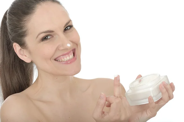 Hermosa mujer joven aplicando crema facial —  Fotos de Stock