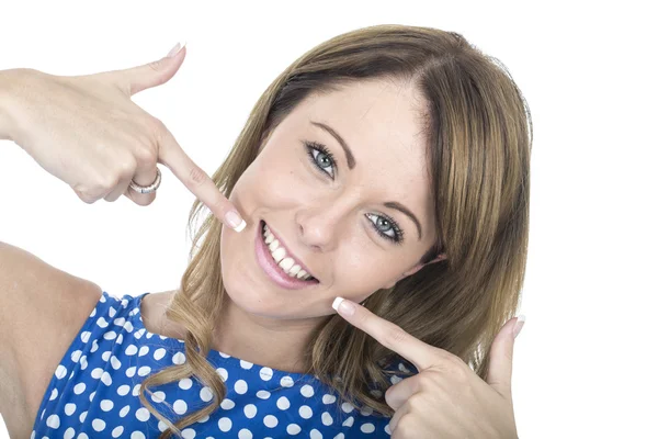 Jonge vrouw draagt blauwe polka dot jurk wijzend op tanden — Stockfoto