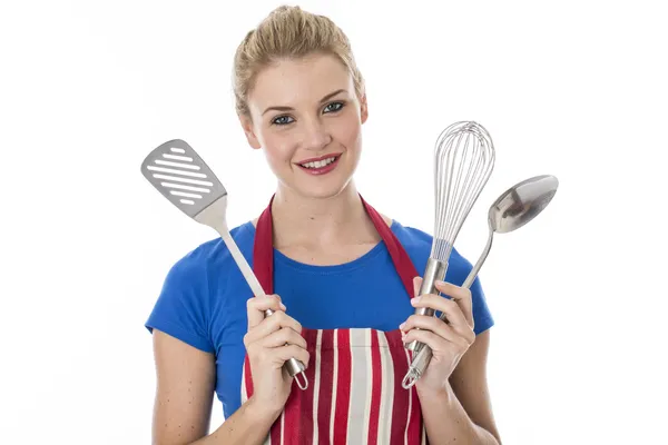 Jovem mulher segurando utensílios de cozinha — Fotografia de Stock