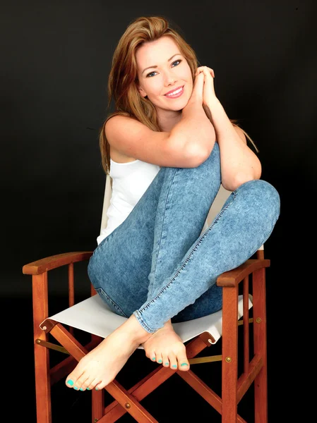 Vacker ung kvinna sitter i en stol — Stockfoto