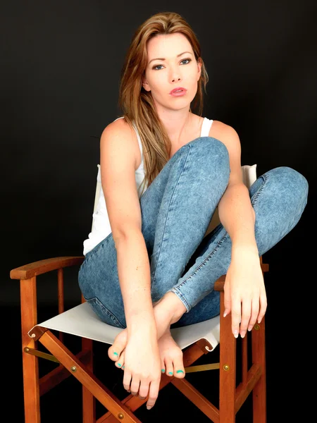 Vacker ung kvinna sitter i en stol — Stockfoto
