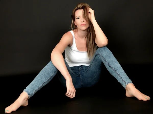 Sexig ung kvinna som sitter på golvet — Stockfoto