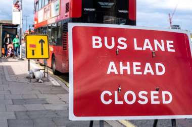 Londra 'daki Waterloo Köprüsü' nde otobüs durağında trafik ışıklarıyla bekleyen bebek sandalyeli genç bir aile ya da puset