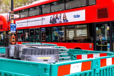 Geleneksel Red London Çifte Descker Toplu Taşıma Otobüsü Londra 'nın orta kesimindeki yol çalışmalarının yanına park etti.