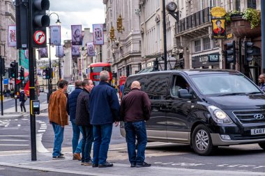 Westminster Londra 'da trafik ışıklarında dikilen bir grup orta yaşlı adam yolu geçmek için bekliyor.