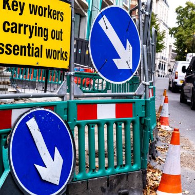 Yeşil güvenlik engelleri ve trafik konileri ile devam eden bina ve inşaat çalışmalarını korumak için halktan uzaklaştırılmıştır.