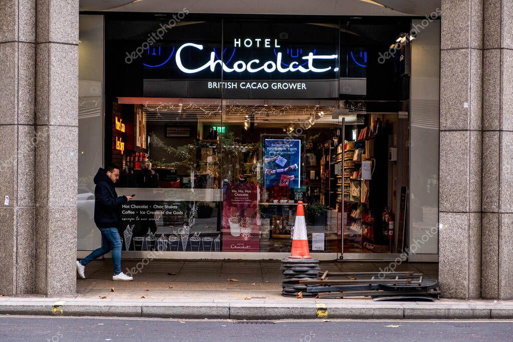 Victoria London England UK, November 21 2021, High Street Retailer Hotel Chocolat Shop Front with A Person Walking B