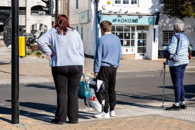 Epsom Surrey İngiltere, 19 Mart 2022, Pedestrian Kontrollü Trafik Işıkları 'nda Karşıya Geçmeyi Bekleyen Küçük Erkek ve Kadın Grubu