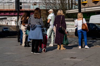 Kingston-Upon-Thames, Kingston Londra, 23 Mart 2022, Trafik ışıklarının karşısında sohbet eden bir grup insan