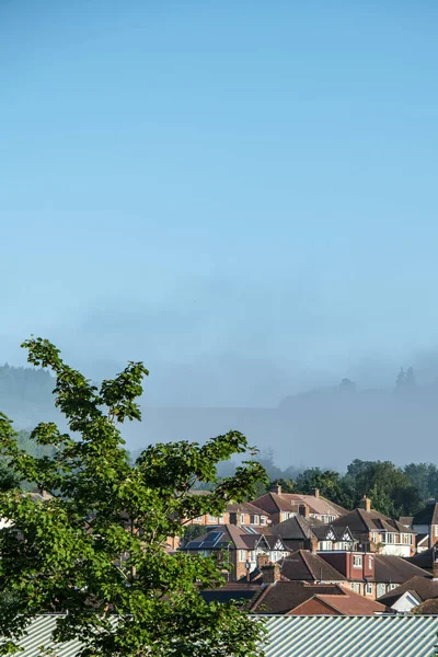 Dorking, Surrey Hills, London, UK, August 26 2022, Residential Houses With Mist On The Background Hills Under A Clear Blue Sky