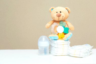 Oyuncak ayı ve süt şişeli bebek bezi yığını. Çocuk için hazırlan, bebek partisi, fotokopi odası, düz yatak