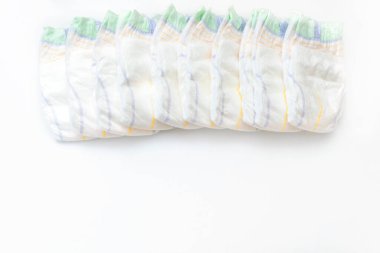 Bebeğin bebek bezleri beyaz arka planda fotokopi alanı ile birlikte duruyor. Yeni doğan, bebek, bebek partisi hediyeleri, sağlık sigortası konsepti.