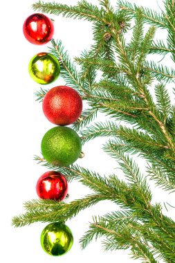 Renkli kırmızı yeşil toplar ve köknar ağacı dallarından oluşan boş çerçeveli Noel bezi. Beyaz arka planda yeni yıl süslemeleri. Tebrik kartı şablonu, düz, üst görünüm.