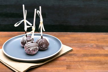 Lezzetli çikolatalı kek, peçeteye beyaz serpiştirilmiş tabaklar, ahşap arka plan, hamur tatlısı, bantla yapıştırılmış tatlılar. Lezzetli yemekler. Boşluğu kopyala.