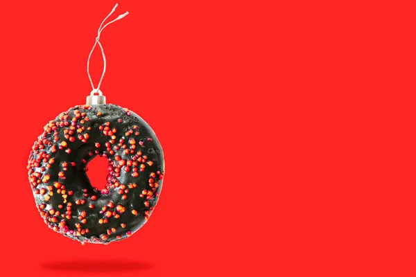 Julgranskula dekoration leksak gjord av sött socker choklad svart glaserade munk donut dessert på rosa pastell bakgrund. Kreativ minimal semester mat koncept kopiera utrymme — Stockfoto