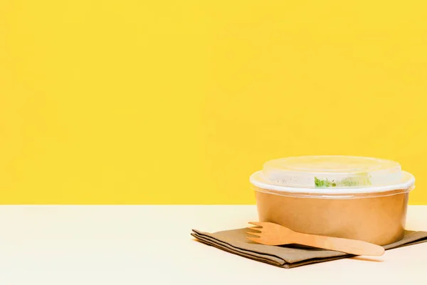 Healthy food lunch in kraft paper carton eco friendly box disposable bowl packaging container on yellow background. chicken, eggs, rice, greens. Take away delivery. environment protection. copy space