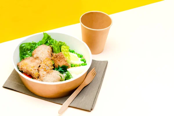 Healthy food lunch in kraft paper carton eco friendly box disposable bowl packaging container, cup on yellow background. chicken, eggs, greens. Take away delivery. environment protection copy space.