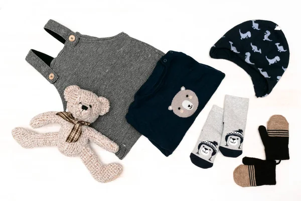 针织毛衣，毛衣，毛衣，袜子，手套，泰迪熊。一套时尚的新生婴儿服装和配饰在白色背景上的淡淡的色彩。平躺在地上，俯瞰四周 — 图库照片