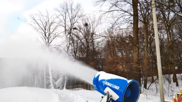 雪山の近くに人工的な雪の粉を作る雪の大砲 晴れた日には冬のリゾート 下り坂やスポーツ活動 — ストック動画