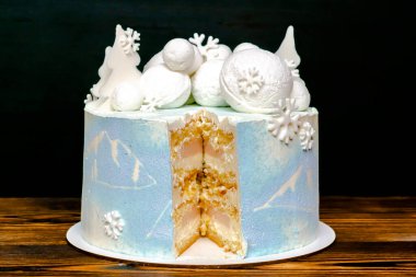 Beyaz mavi sünger lezzetli vanilyalı kremalı pasta büyük yuvarlak marshmallow, çikolata kar taneleri, köknar ağaçları, dağ resmi, çilek katmanlı kesilmiş tatlı..