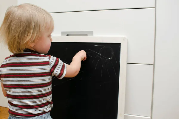 かわいいかわいいかわいい白人の少年は自宅で黒板にチョークを描く 子供の手の絵 子供のための創造的な面白い屋内活動 幼児保育園 幼稚園のコンセプト — ストック写真