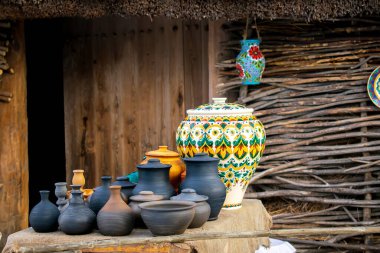 Farklı kil tabaklar yemek takımları, kavanozlar, esnaf pazarında ahşap arka planda farklı hediyelik eşyalar. Antika çömlek seramik seti. Ulusal Slav el yapımı kil donanımı.