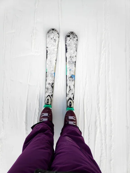 白い氷の雪の表面にスキーで女性の足のビューの上に 山のトラックの背景 下り坂でのスキー脚の直線行のスキー場の斜面を開始します ウィンタースポーツアウトドアコンセプト — ストック写真