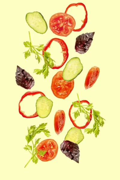 Ljus vårsallad med flygande flyter i luft ingredienser, färska vitamingrönsaker. Avstängd tomat, gurka, peppar, persilja, basilika. Vegetarisk vegan hälsosam mat meny — Stockfoto