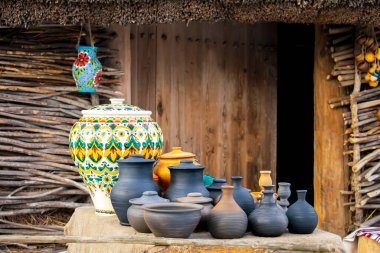 Esnaf pazarında ahşap zeminde farklı tabaklar, kavanozlar, hediyelik eşyalar. Antika çömlek seramik seti. Ulusal Slav el yapımı kil eşyalar, Ukrayna mirası