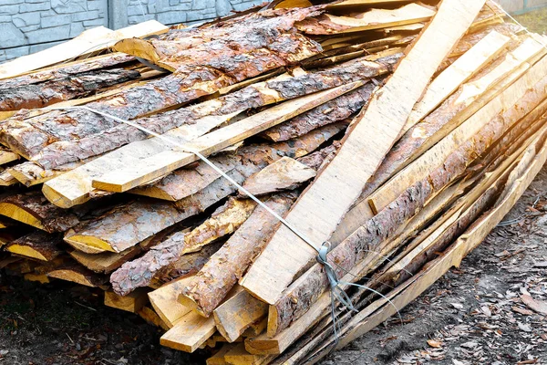 Промышленная древесина для столярных работ, строительства или ремонта, пиломатериалы для кровельного строительства. стеллажи натуральные нарезанные сухие стволы, дрова пожарные, приготовленные на зиму, готовые к сжиганию — стоковое фото