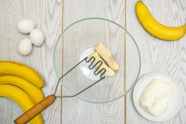 Esmagar várias bananas para assar em pão, cupcakes. preparação de ingredientes para fazer muffins de queijo cottage, caçarola na cozinha doméstica, cozinhar on-line, instrução de receita — Fotografia de Stock