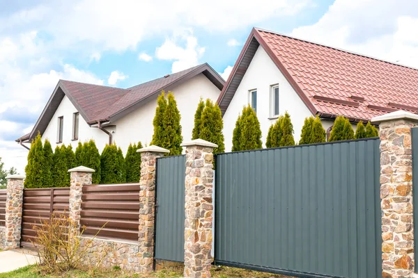 Arka bahçesi yüksek çitlerin arkasında olan özel bir banliyö evi. Yeşil thuja çitli ekolojik alanda güzel bir kır evi kompleksi. Modern mimari, zenginlik ve lüks konsept.