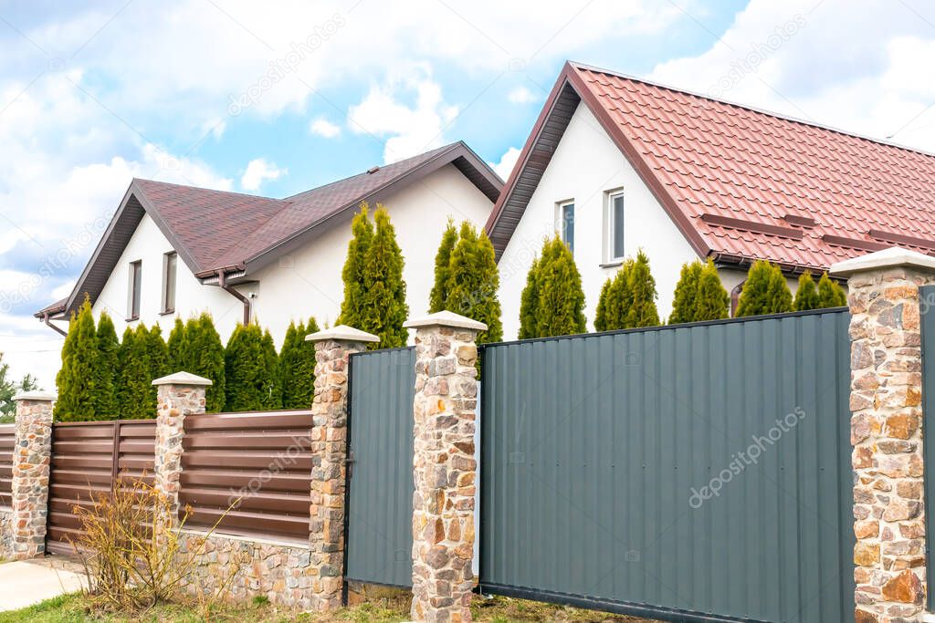 private suburban house with back yard behind high fence. beautiful landscape recreation cottage complex in ecological area with green thuja hedge. Modern architecture, riches and luxury concept.