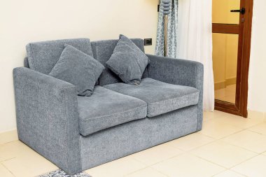 Parlak ve klasik bir süit, modern iç mimarisi olan bir otel odası, gri kanepe, kanepe, yastıklar. Tatil tatili konsepti. Şehir içi çağdaş iç tasarım.