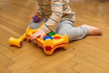 Kafkasyalı şirin bir çocuk oynuyor, çok renkli tasnifçi topluyor. Bebeğin elleri plastik oyuncakları ayırıyor. Çocukların mantık gelişimi, çocuk yuvası eğitimi, anaokulu kavramı.